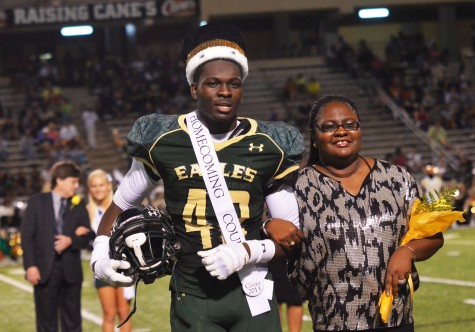 Otaro Alaka stands with his mother during half time at the homecoming game to claim his title as king.