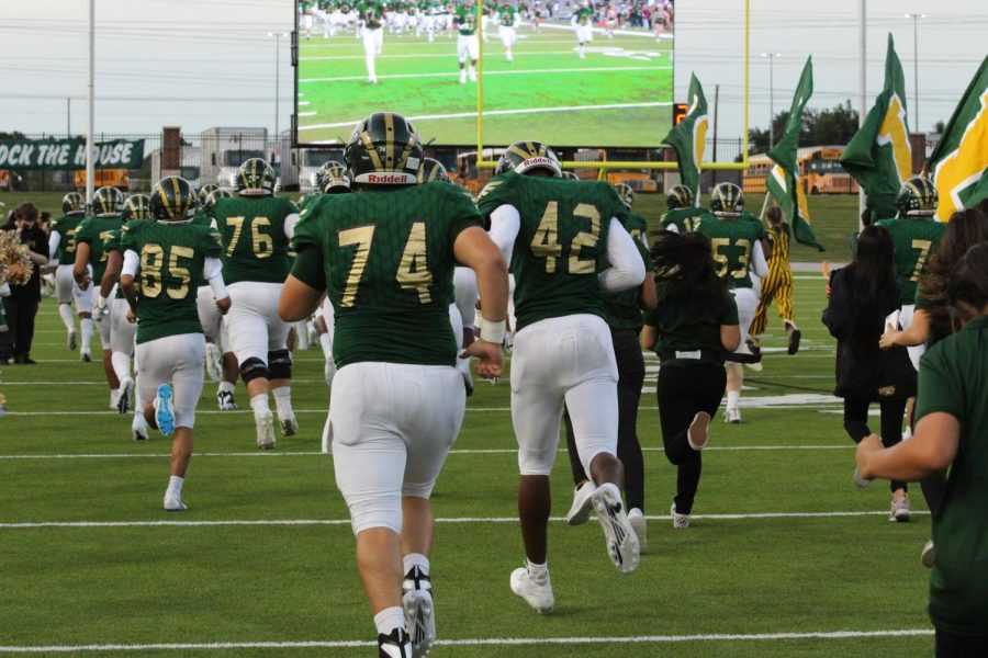 The varsity football players take the field vs. Cy Creek