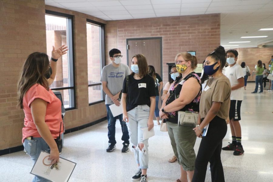 Freshmen and their parents listen to admin’s tours around the school. 
