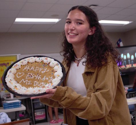 Club President holding up cookie cake in celebrating of fashion instructor's birthday